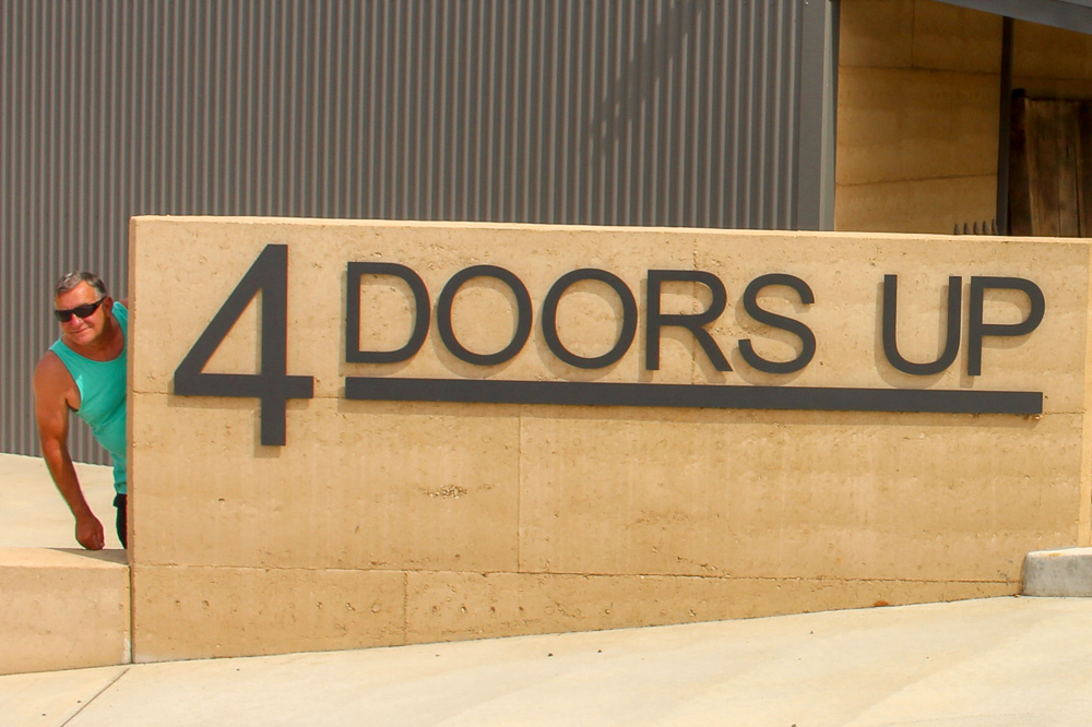 Greg beside 4 Doors Up sign